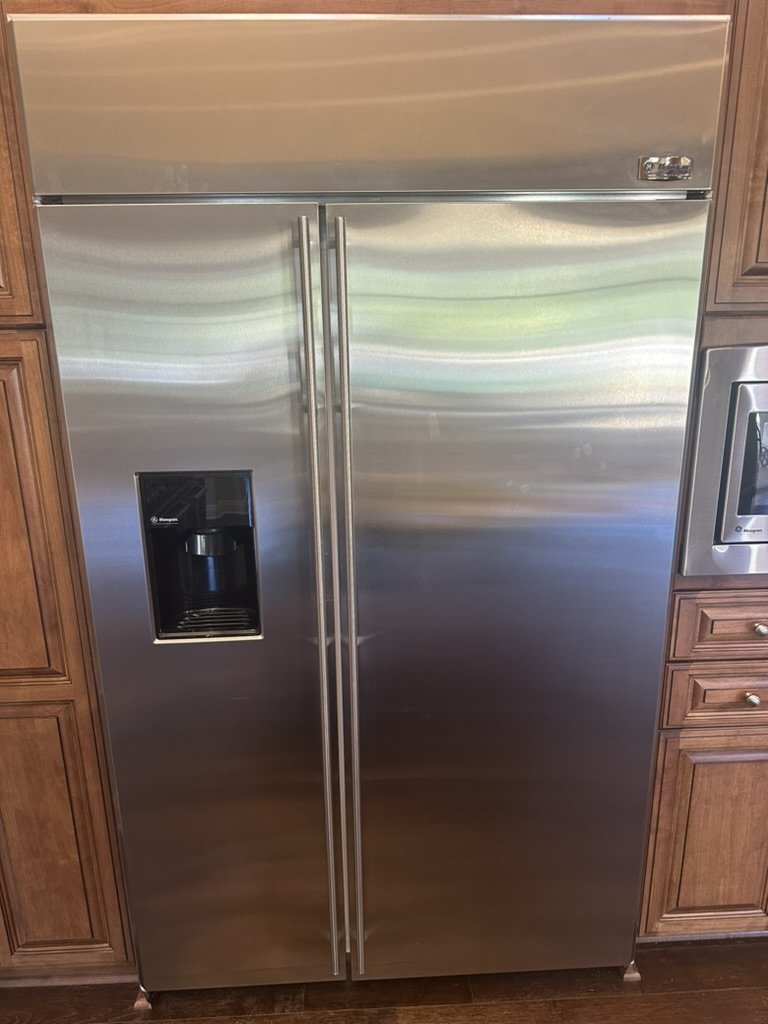 Monogram built-in stainless side-by-side refrigerator with dispenser in wood cabinetry