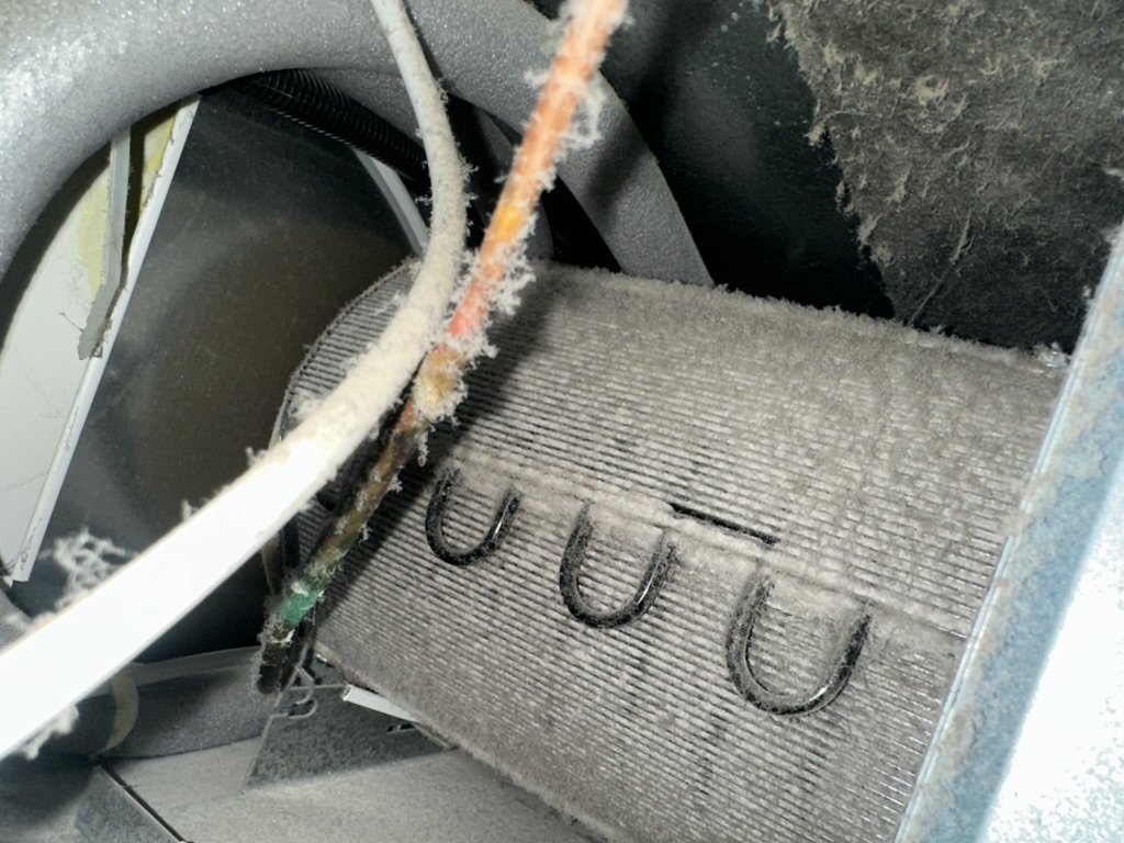 Heavy dust buildup on the condenser coil of a Monogram built-in refrigerator