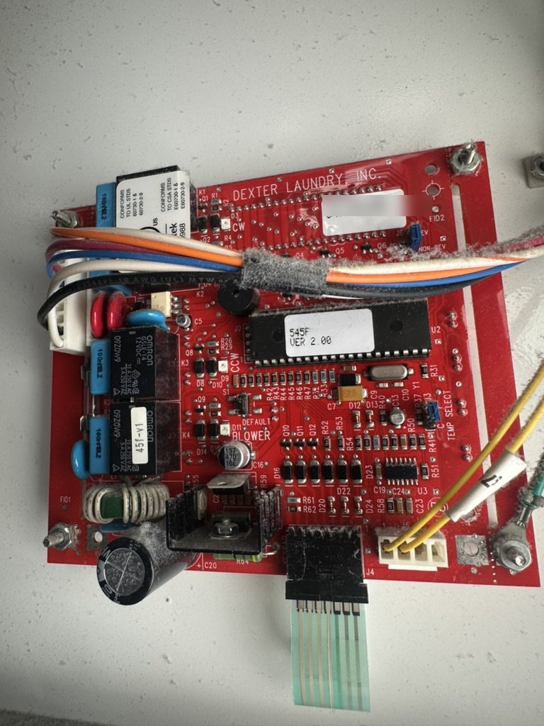 Control board from a Dexter commercial dryer, covered in lint, during replacement