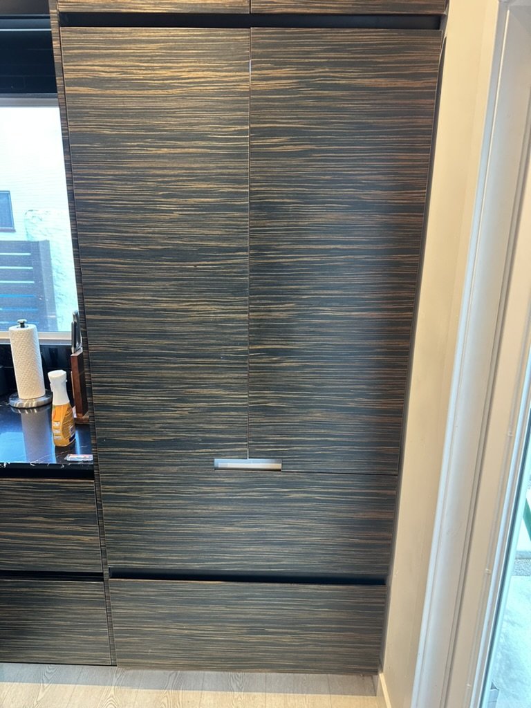 Miele built-in French-door refrigerator hidden behind custom wood panels