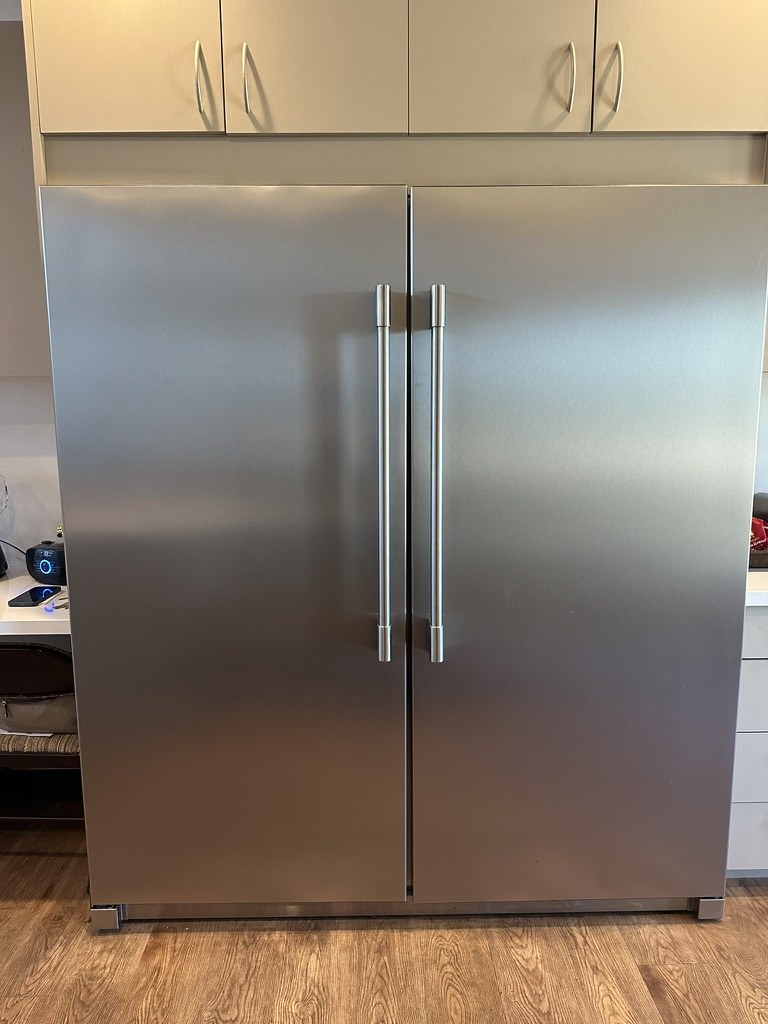 Frigidaire refrigerator and freezer installed side by side between kitchen cabinetry